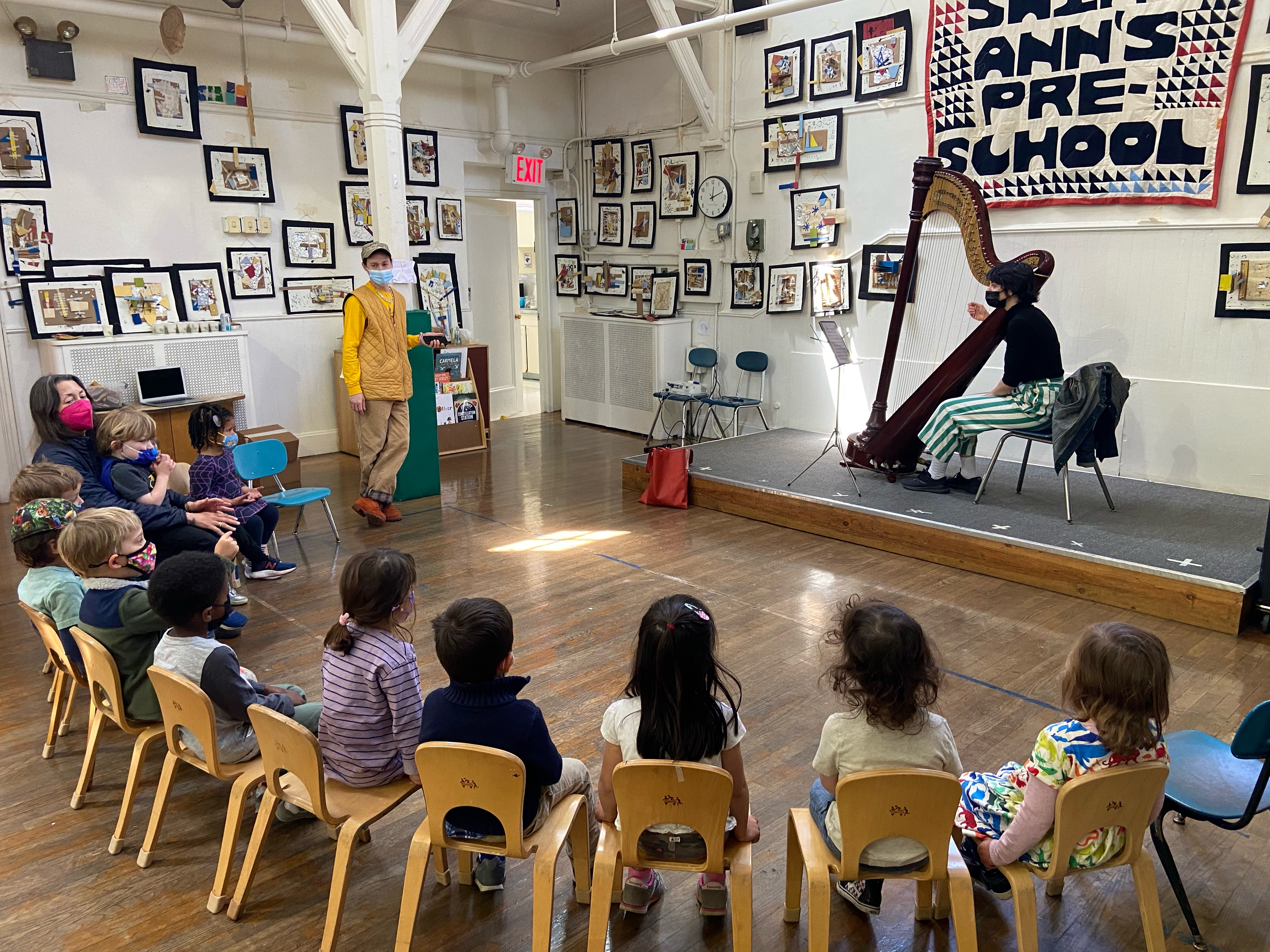 Esther Sibiude teaching harp to class of children.